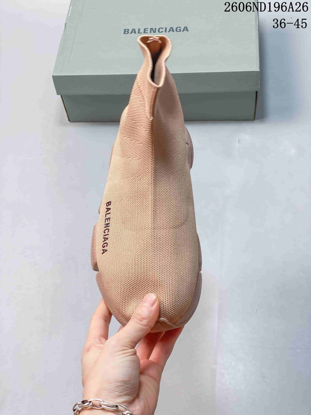 Top view of the beige knit sneaker showing the rounded toe, sock-like opening, and side branding.