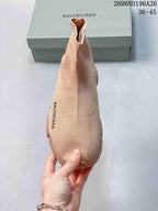 Top view of the beige knit sneaker showing the rounded toe, sock-like opening, and side branding.