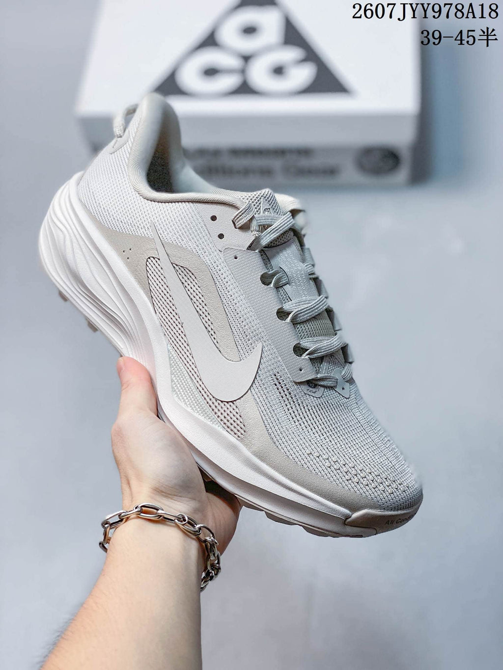 Light gray Nike ACG Pegasus Trail sneaker showing the textured upper, Swoosh branding and lace system.