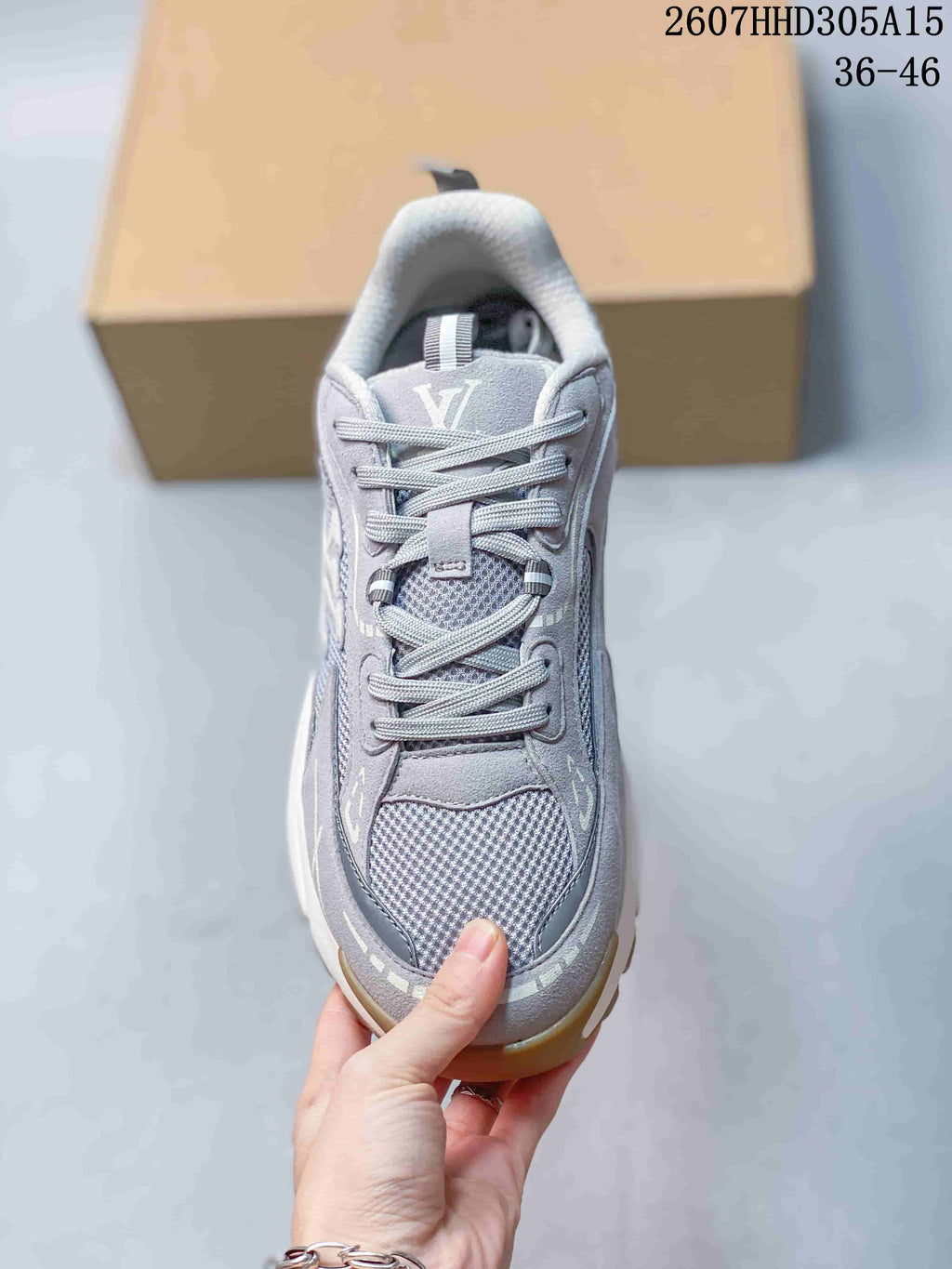 Top view of the gray lace-up sneaker showing the padded tongue, laces, mesh toe panel, and visible Louis Vuitton branding.
