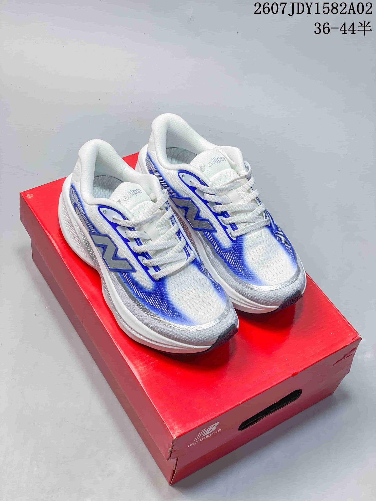 Pair of white and blue New Balance running shoes displayed on a red box