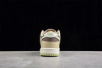 Rear view showing the beige heel, layered brown detailing, white midsole, and light green outsole.