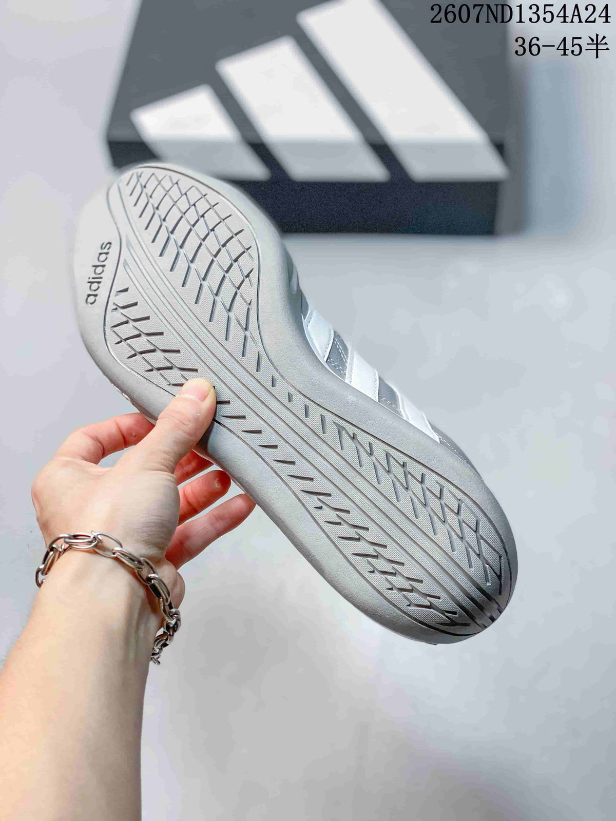 Close view of the patterned outsole and adidas branding on a gray sneaker.