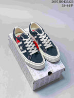 Navy low-top sneakers with white laces, star side emblem and heart-eye graphics displayed on a Converse-patterned box.