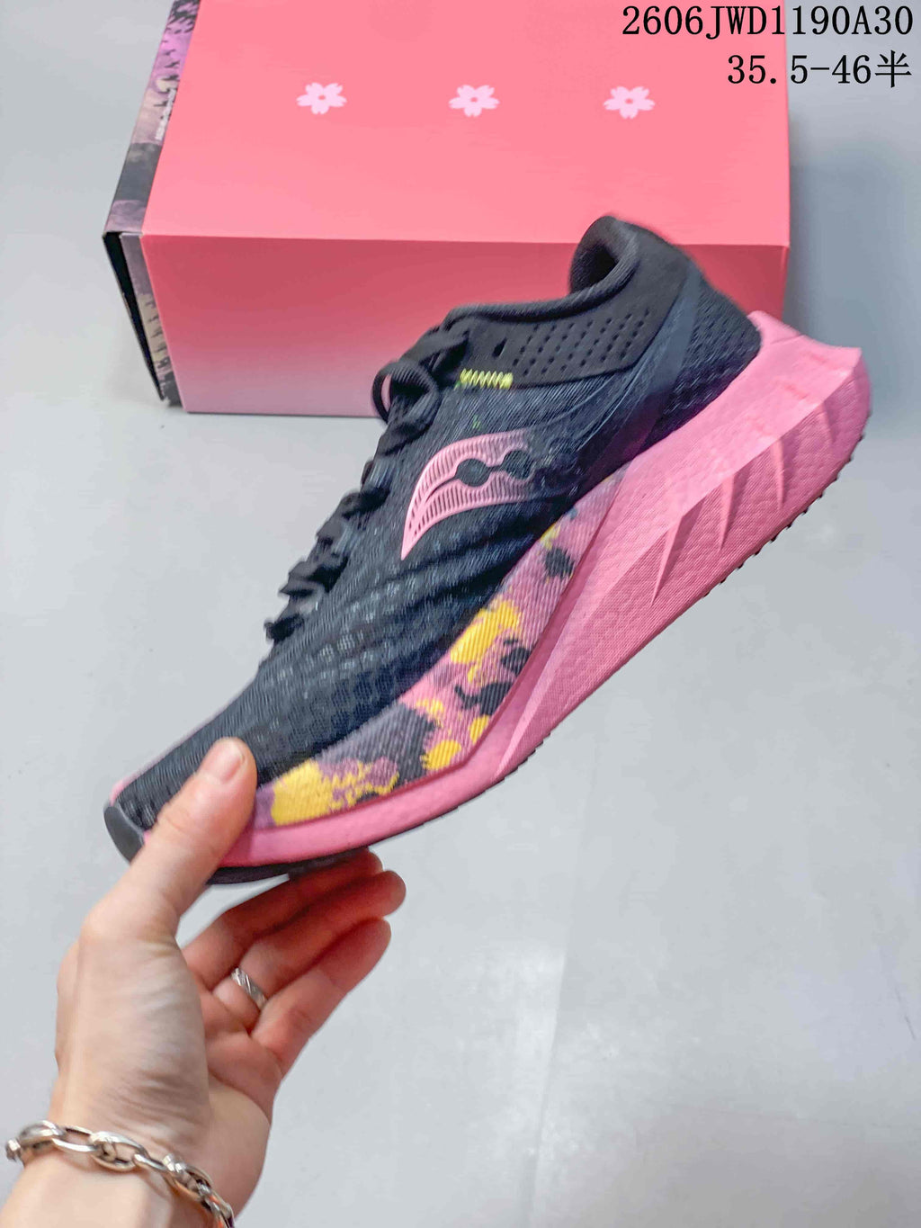 Side view of a dark running shoe with pink and multicolor details
