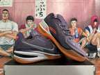 Pair of purple Nike GT Cut 3 basketball shoes with orange accents, shown from the side.