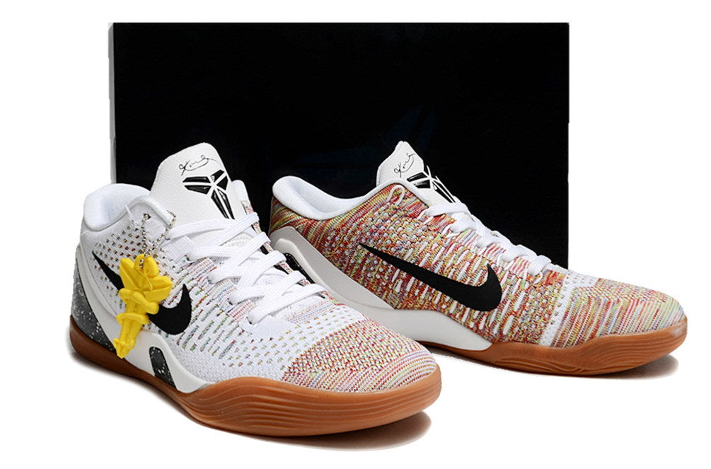 Pair of white and multicolor shoes with gum-colored outsoles and a dark box behind them.