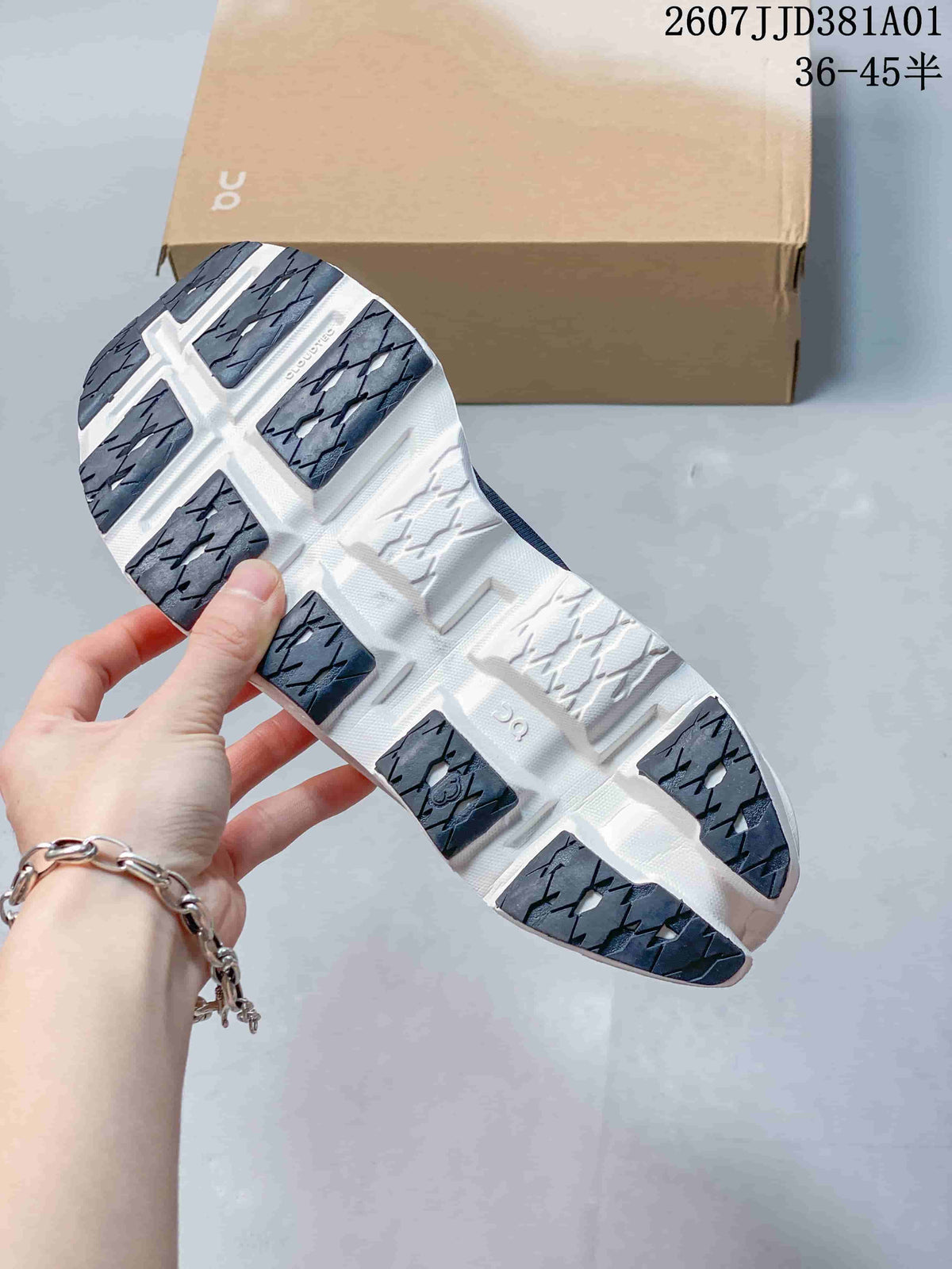 Close-up of the shoe outsole showing dark tread sections against a white sole.