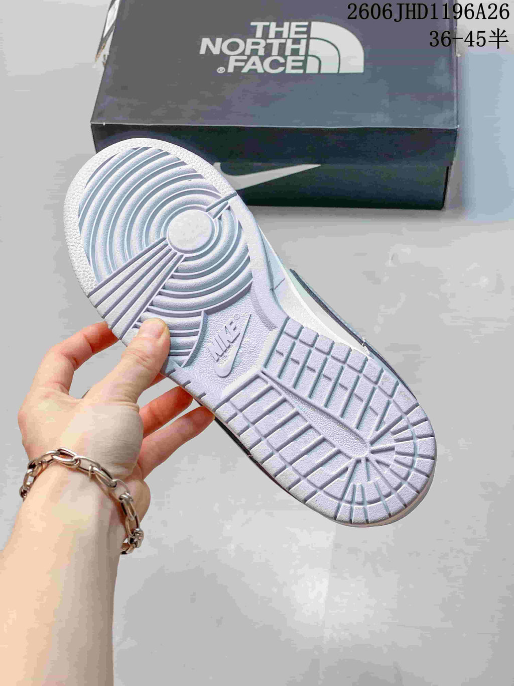 View of the sneaker outsole showing circular and rectangular tread sections.