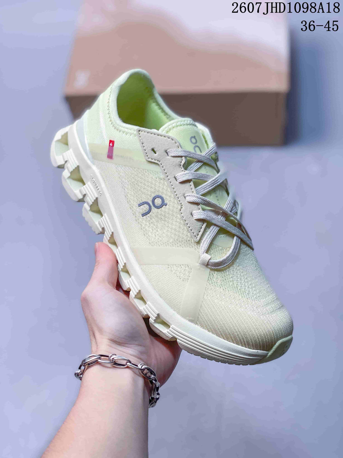 Angled side view of the pale green On sneaker showing the lace system, side logo, and outsole openings.