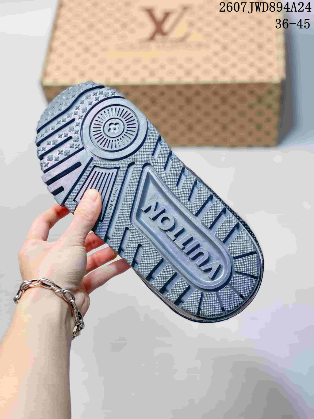 Close-up of the patterned gray outsole with raised branding and textured tread.