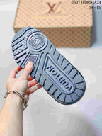 Close-up of the patterned gray outsole with raised branding and textured tread.