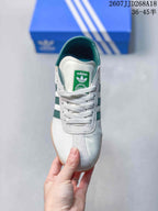 Top view of the white sneaker with green collar lining, tongue label and white laces.