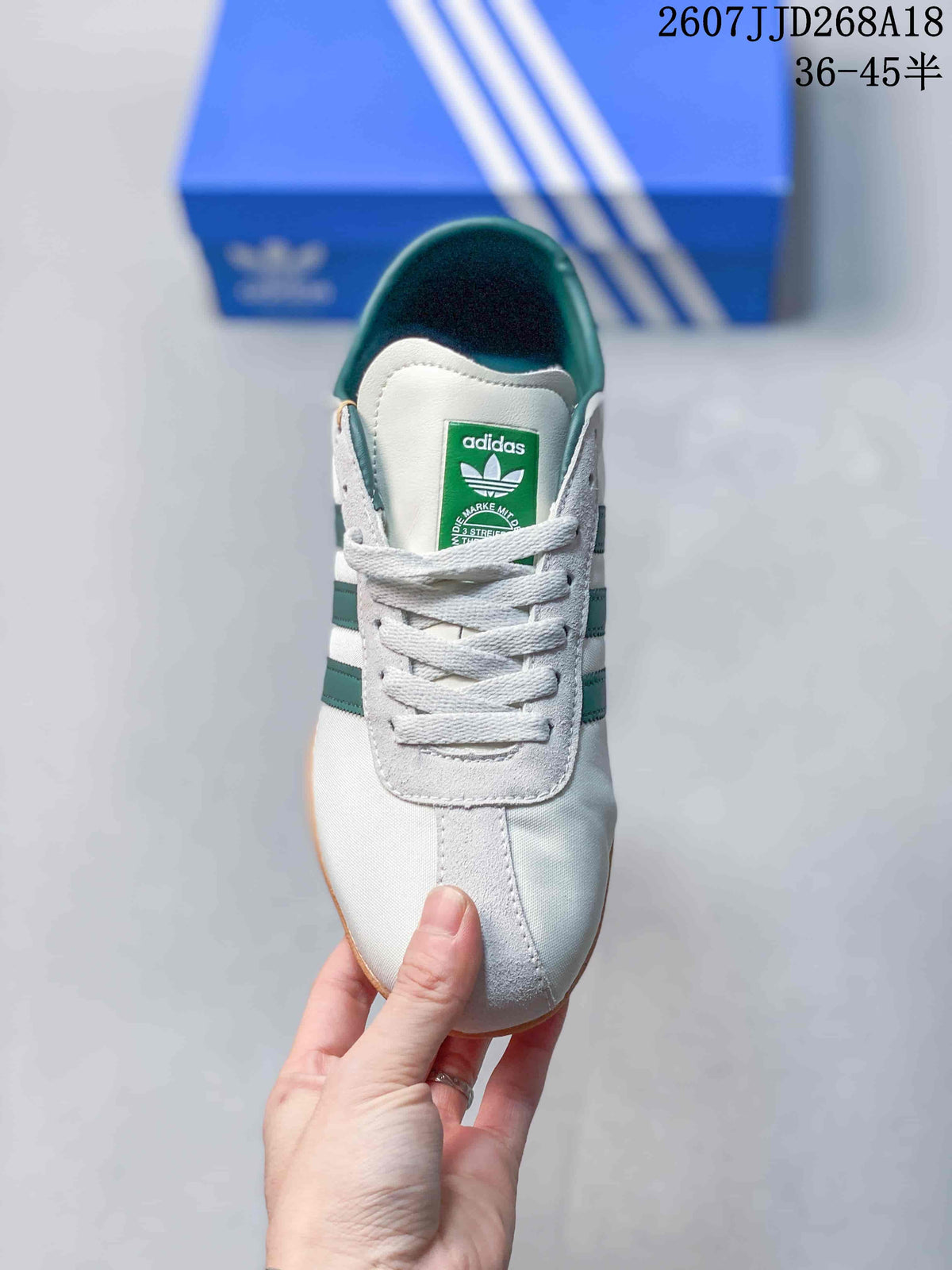 Top view of the white sneaker with green collar lining, tongue label and white laces.