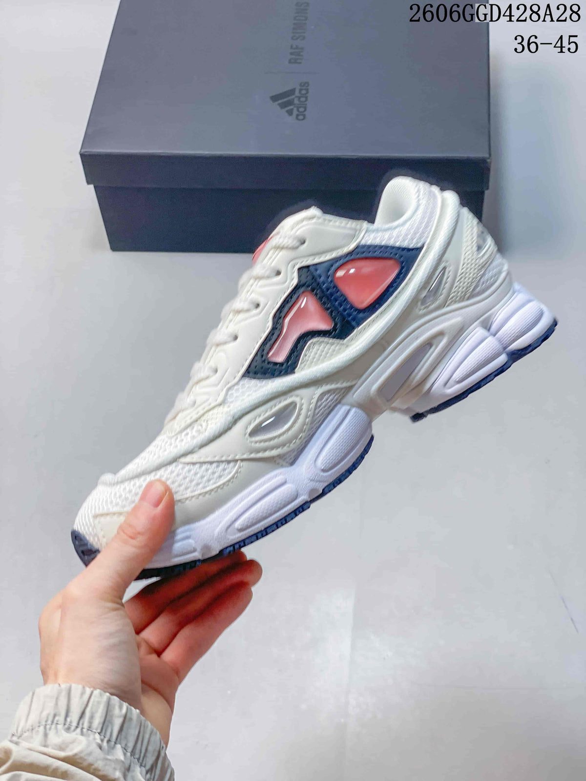 Side view of a white Cylon-21 sneaker with navy and coral-pink accents