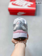 Rear view of the sneaker showing the silver heel panel, pink accent strip, padded collar, and layered white midsole.