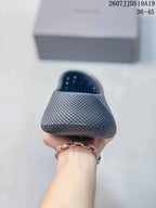 Front view of a gray perforated clog showing the rounded toe, textured surface, and open ventilation holes.