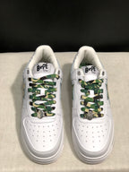 Front top view showing the white perforated toe boxes and green camouflage laces with metal lace accents.
