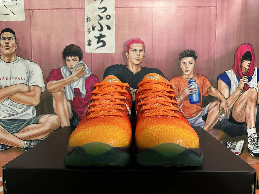Front view of orange-to-yellow textured basketball shoes with orange laces and dark green toe accents