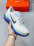 Close-up of a white running shoe with blue and aqua midsole accents