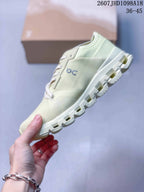 Side profile of the pale green low-top sneaker showing its layered upper and segmented outsole.
