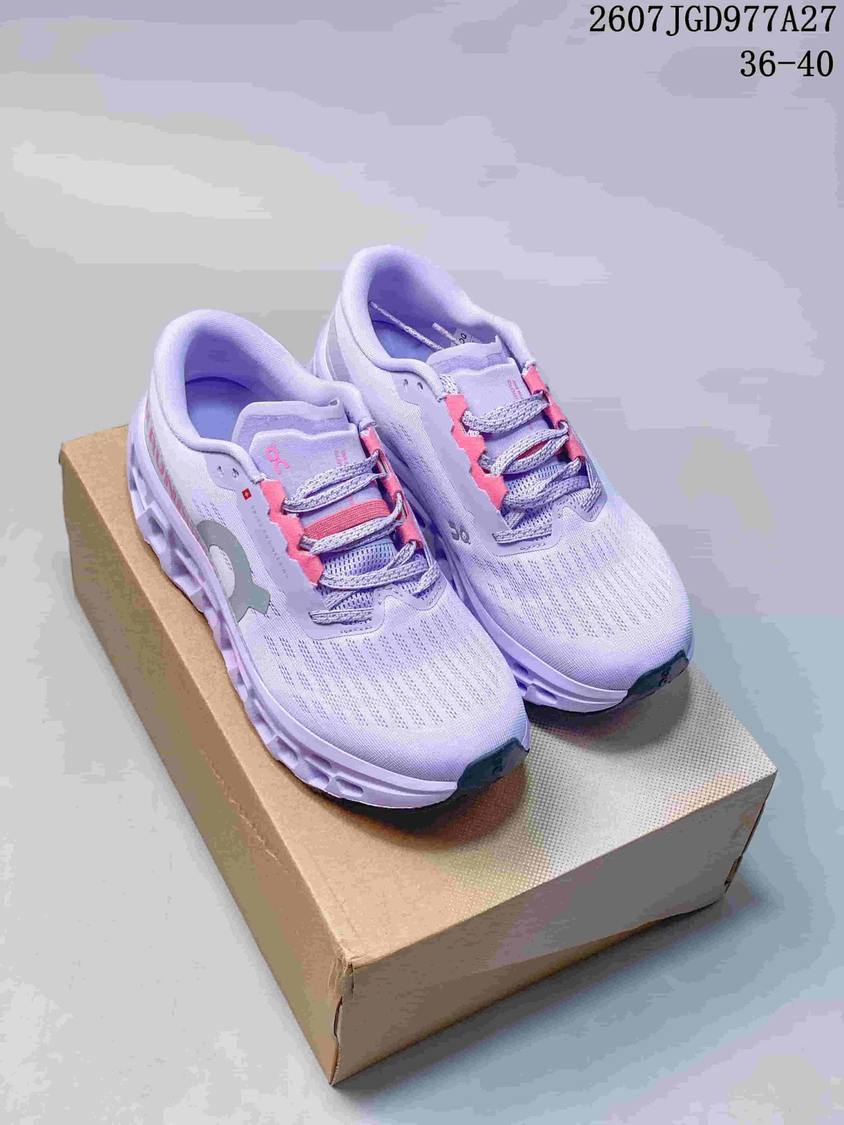 Pair of lavender and pink On running sneakers displayed on a cardboard shoe box; image text shows style code 2607JGD977A27 and size range 36–40.
