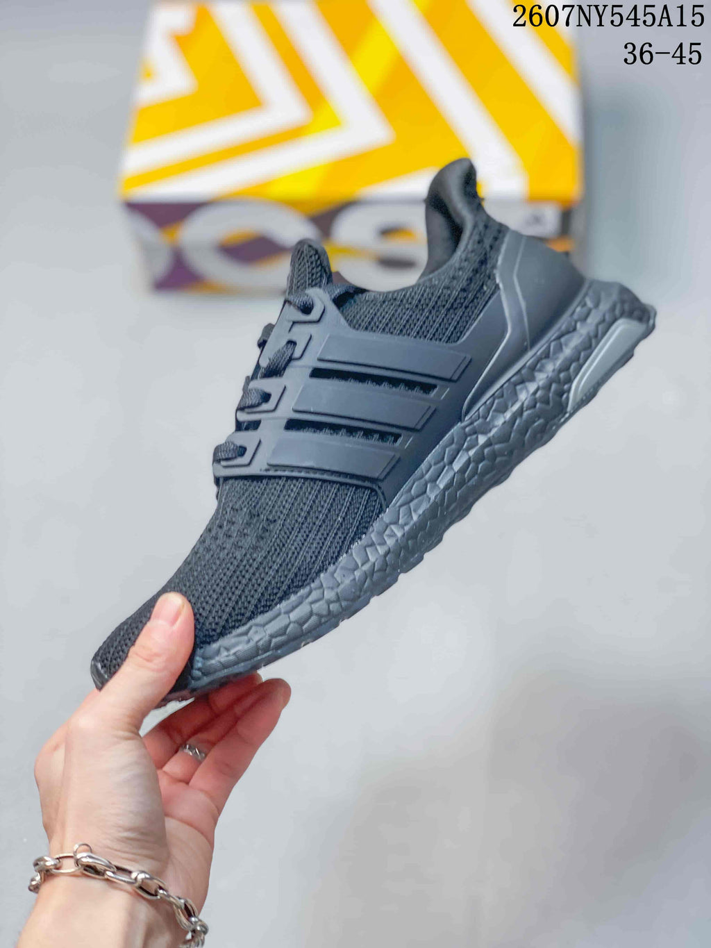 Side profile of the dark gray sneaker showing the knitted upper, molded side cage, lace area, and textured midsole.