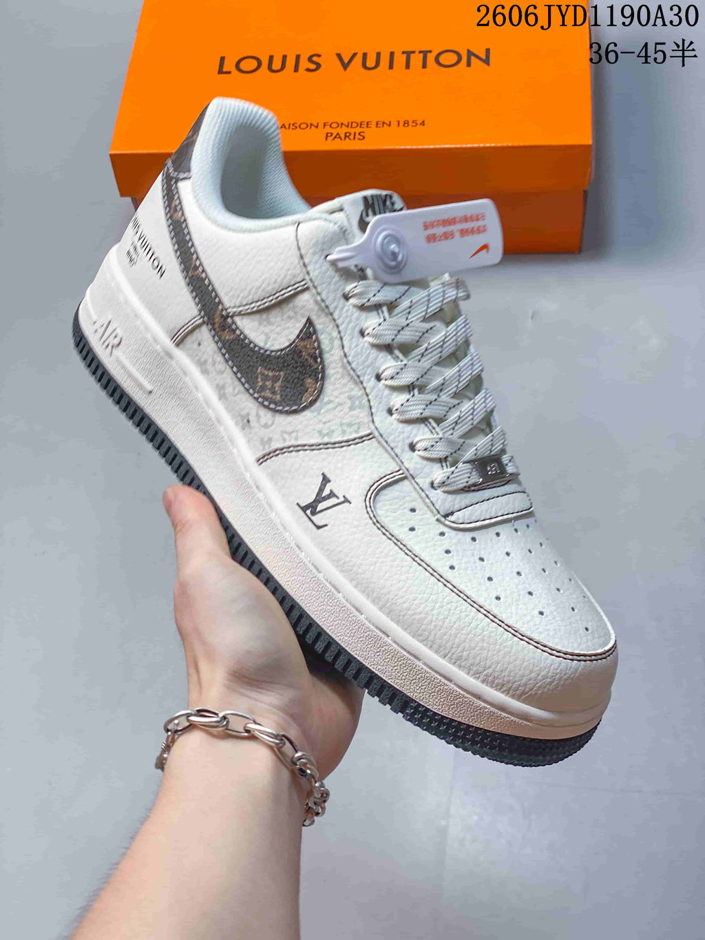 Angled view of the cream low-top sneaker with patterned Swoosh, contrast stitching, and dark outsole.