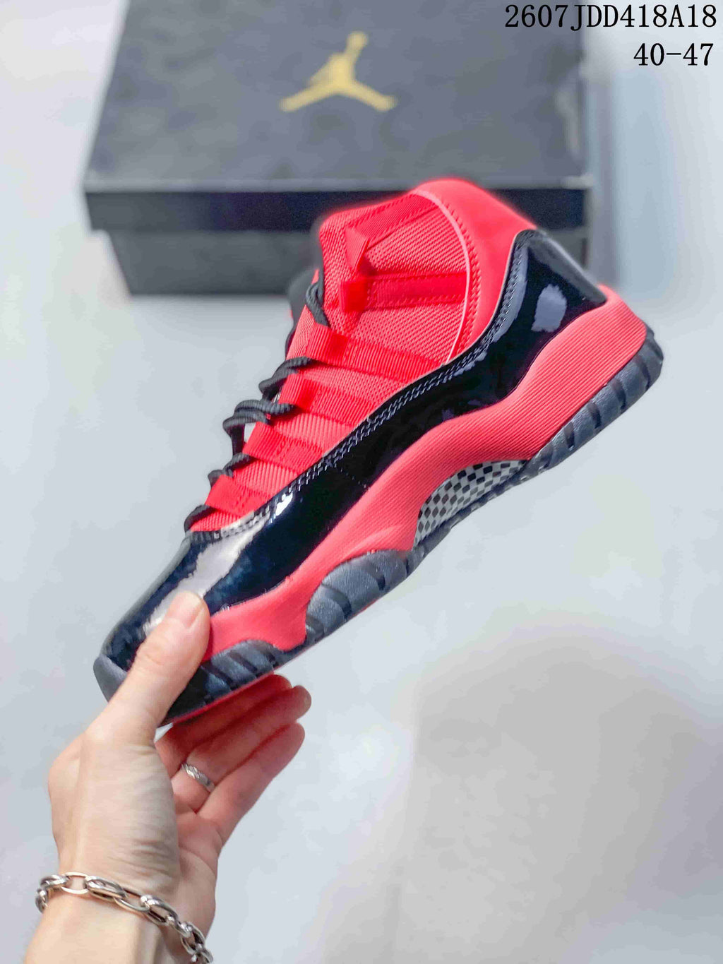 Side profile highlighting the red textile upper, glossy black lower panels, red midsole accents, and dark outsole.