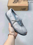Angled side view of the gray low-top sneaker with laces, panel detailing, and dark outsole.