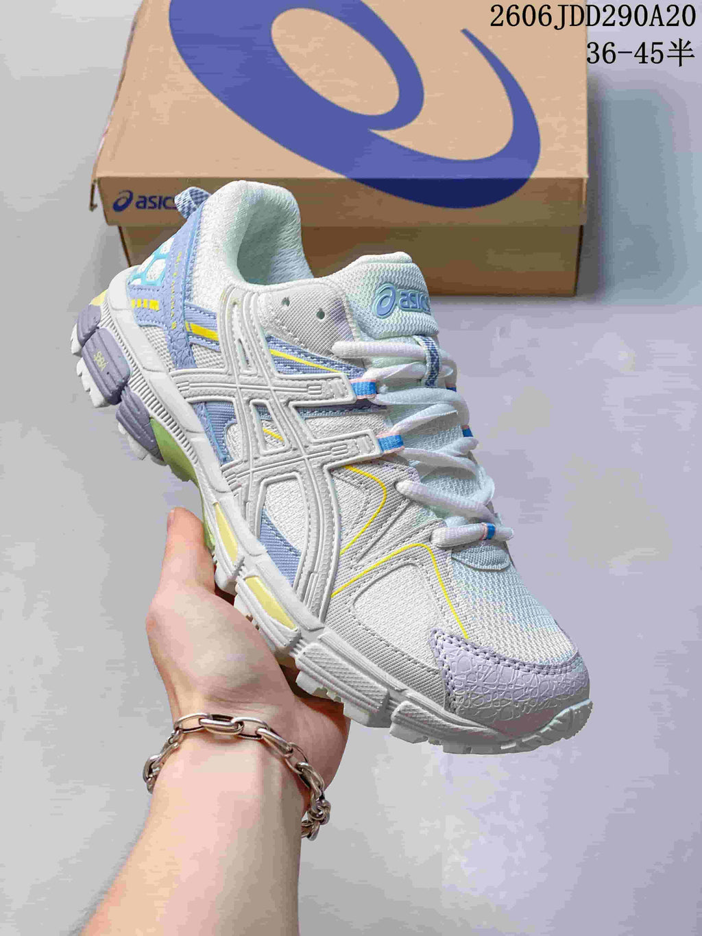 Angled side view of the white and blue ASICS sneaker showing the layered upper and treaded outsole.
