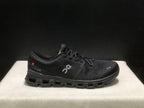 Side view of a black On Cloud X4 shoe with the On logo and heel detail visible.