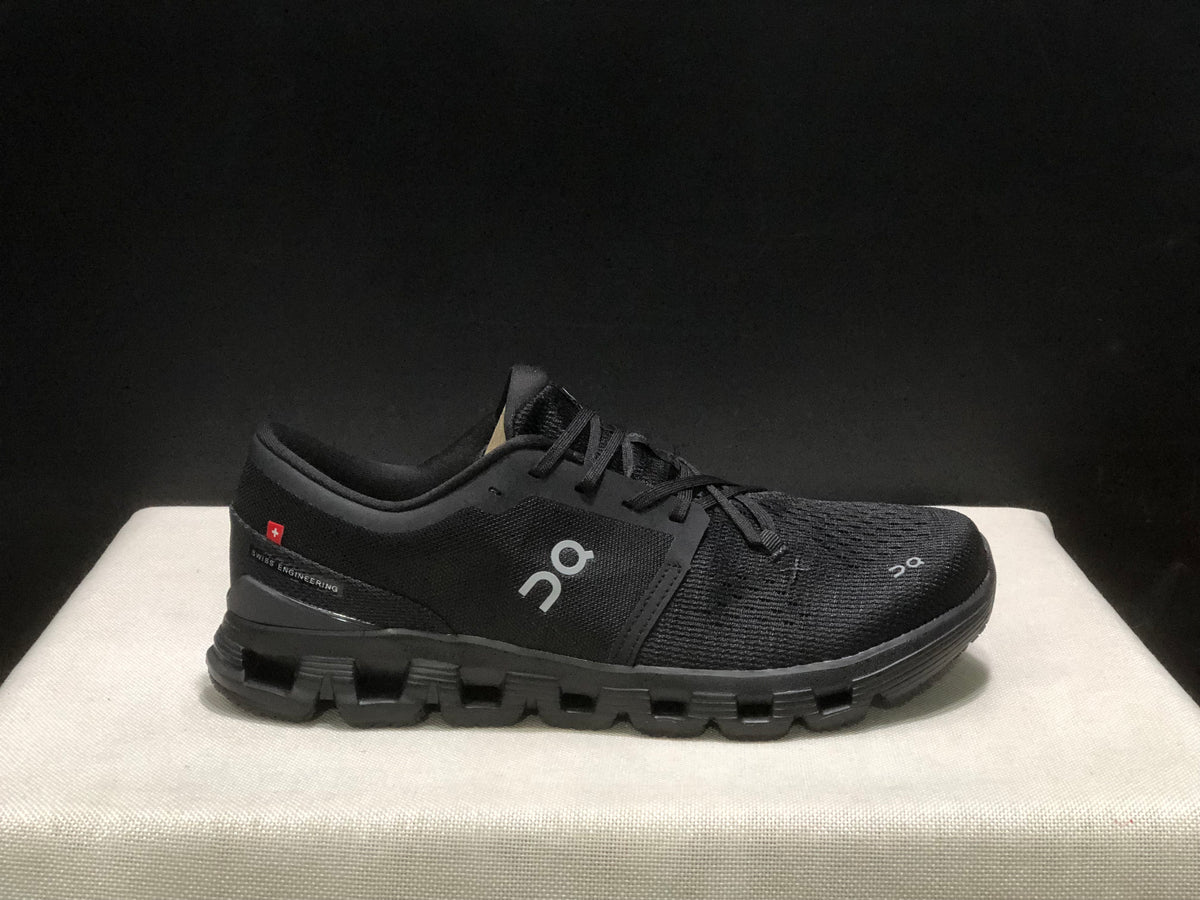 Side view of a black On Cloud X4 shoe with the On logo and heel detail visible.