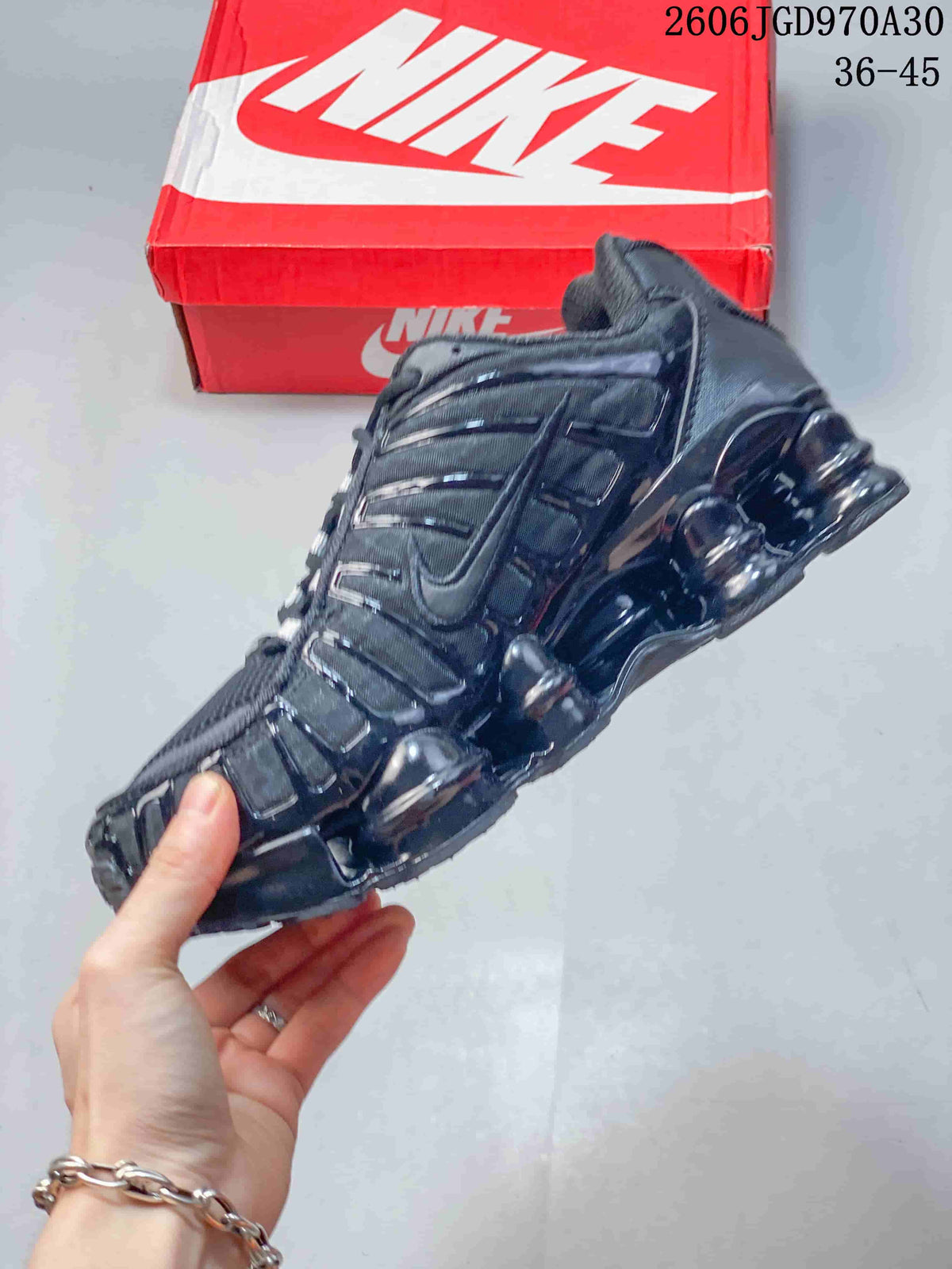 Side view of a dark Nike Shox TL sneaker with layered panels and segmented sole cushioning
