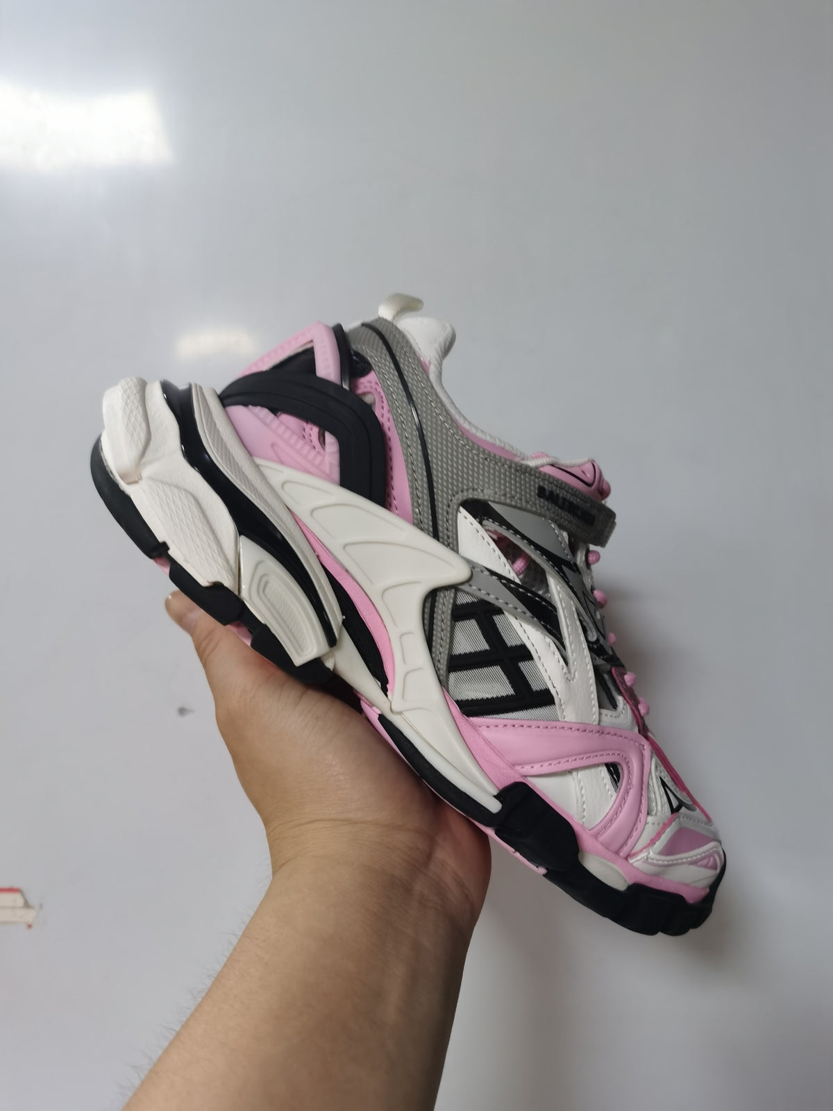 Close-up view of pink, grey, white and black Balenciaga Track.2 sneakers showing the layered upper and sculpted sole.