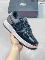Glossy dark low-top sneaker with a white midsole and layered panels