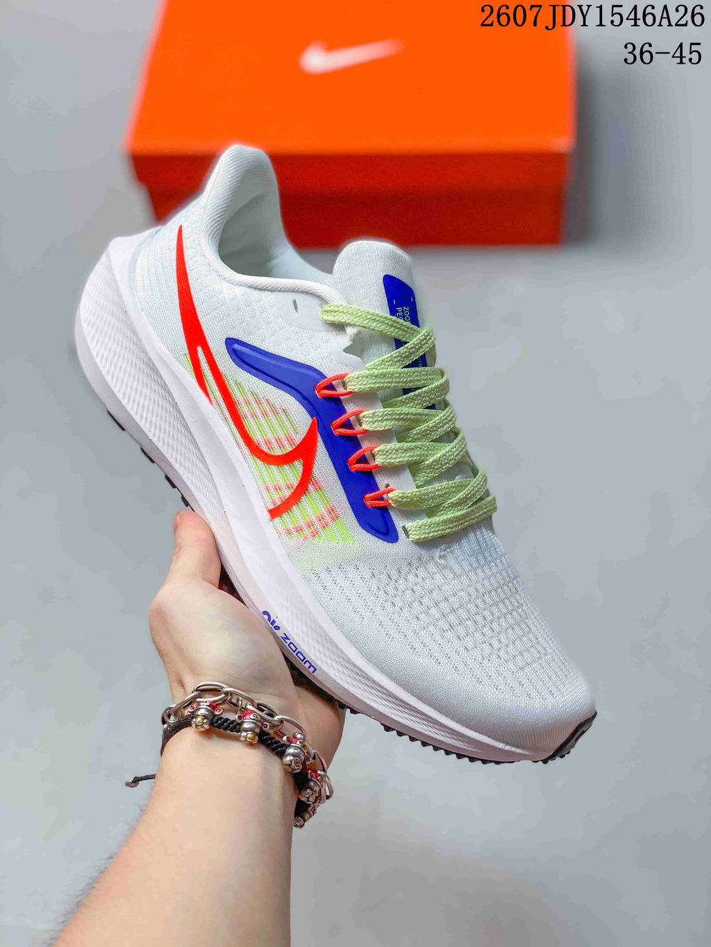 White Nike Air Zoom Pegasus 39 sneaker with bright blue and red side accents and light green laces.