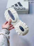 Underside view of the sneaker showing the cream outsole with raised geometric tread and dark adidas branding inserts.