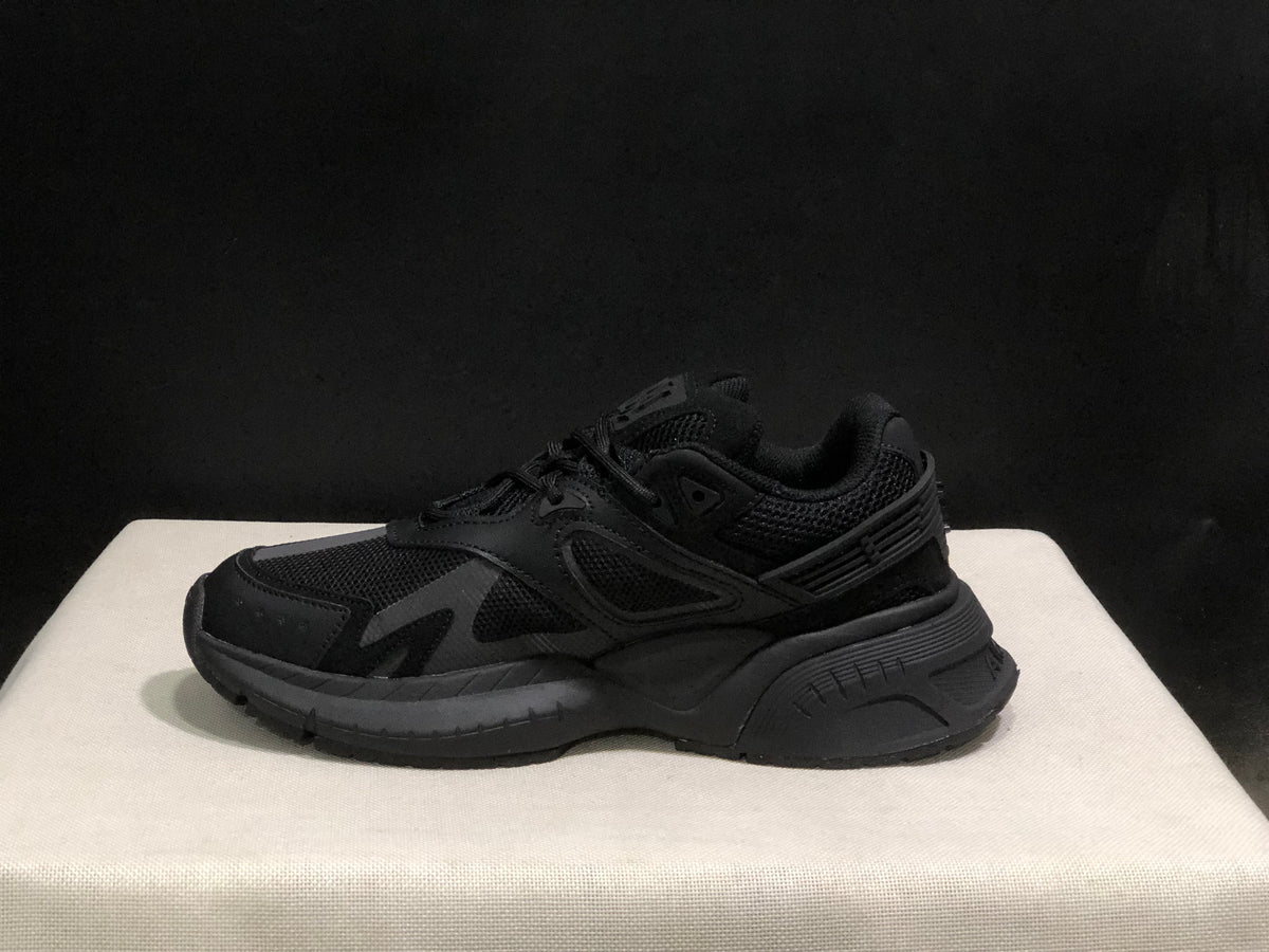 Side view of one black sneaker highlighting the sculpted midsole and heel structure.
