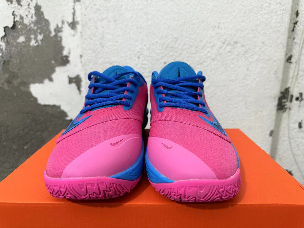 Front view showing pink uppers, blue laces, and pink outsoles