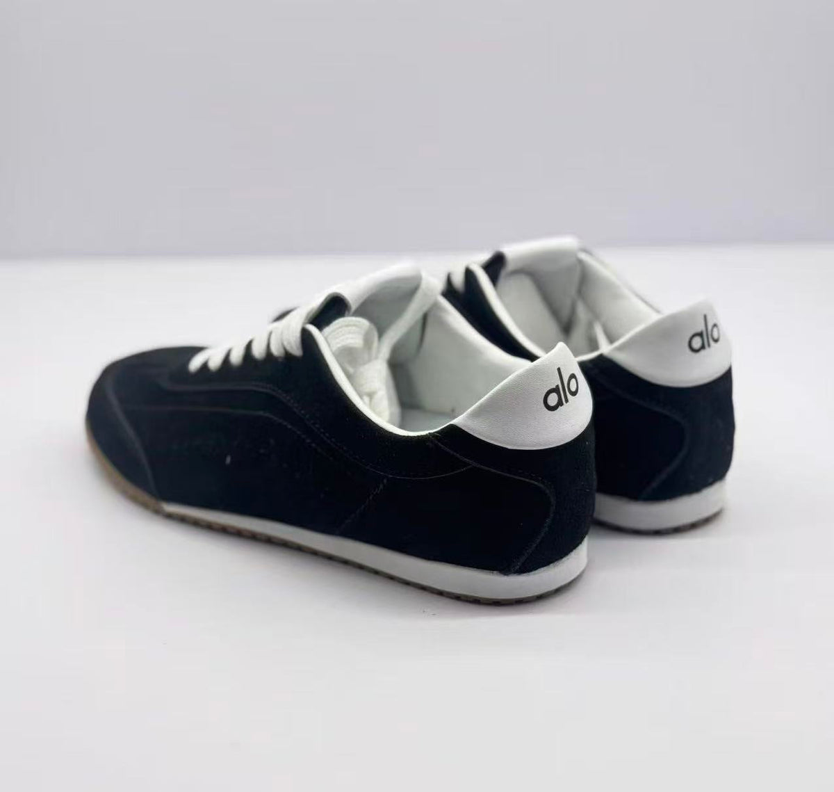 Rear view of the pair with Alo branding on the white heel panels.