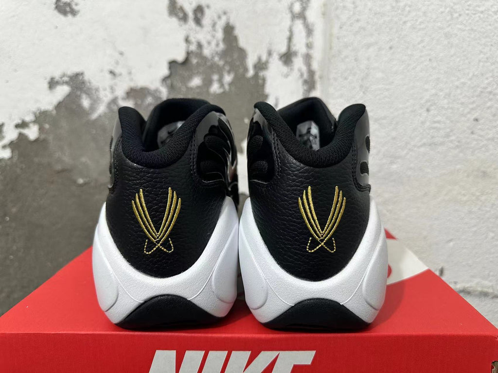 Rear view of black Nike Flight sneakers with gold heel detailing and white midsoles.