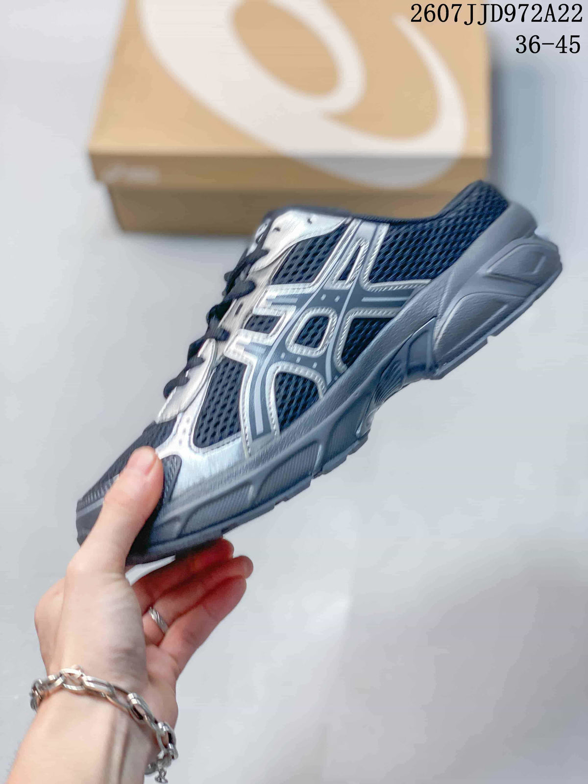 Side profile showing the navy mesh-style upper, silver overlays, and structured sole.
