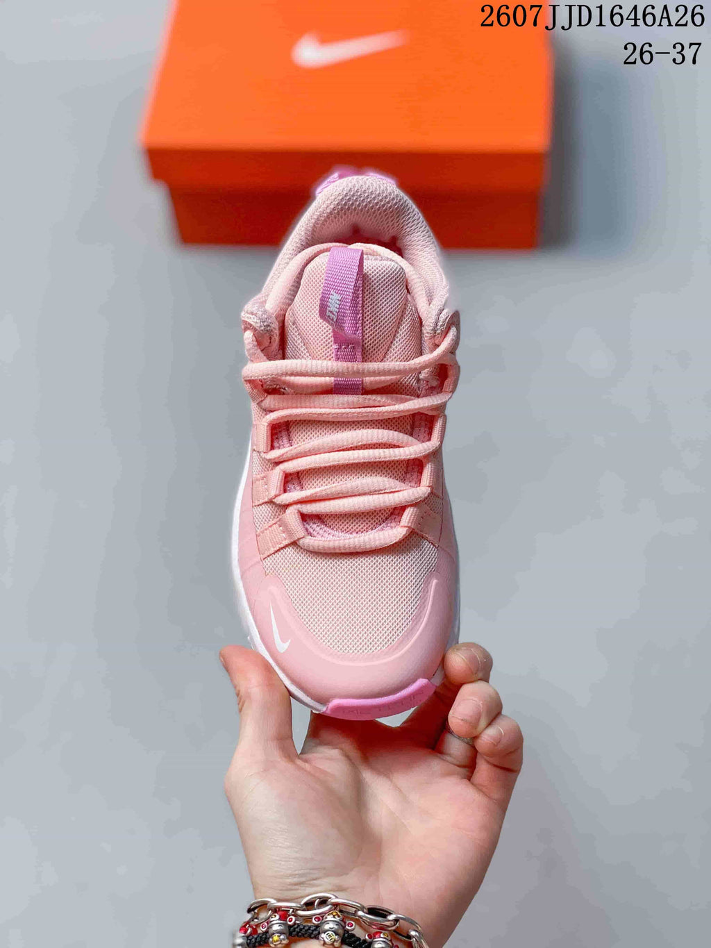 Top view of the pink children's training shoe showing the laces, tongue, textured upper, and toe branding.