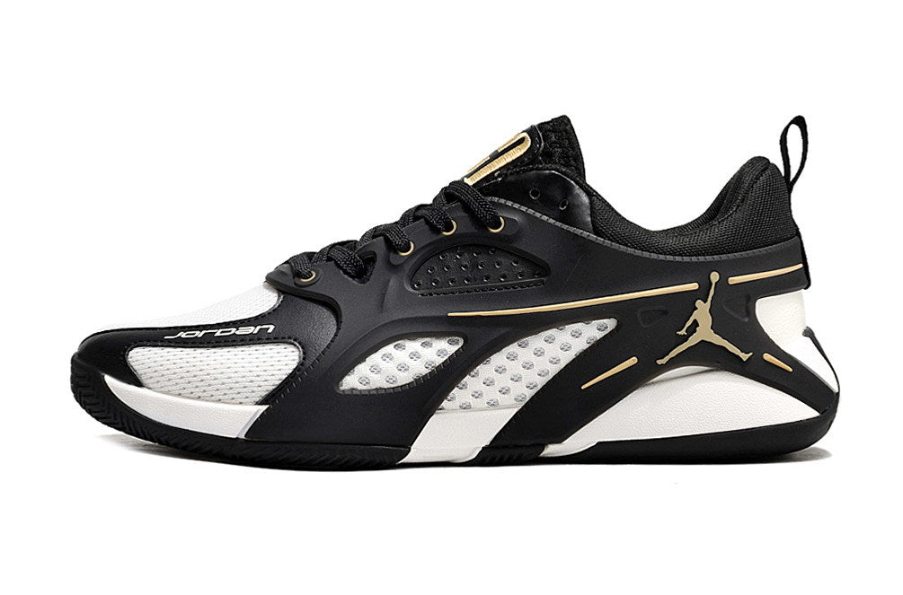 Side profile of a black and white Jordan Heir shoe with gold-tone details