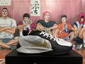 Side view of a white and black Nike basketball shoe with gold-tone Swoosh