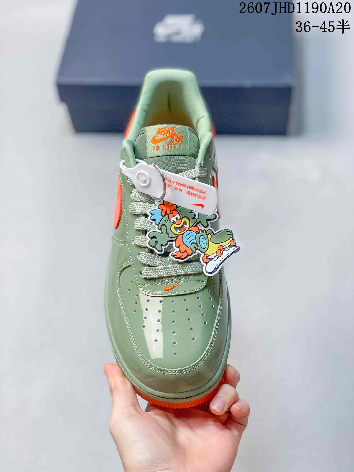 Top view showing the perforated toe box, green laces, orange tongue branding, and cartoon shoe charm.