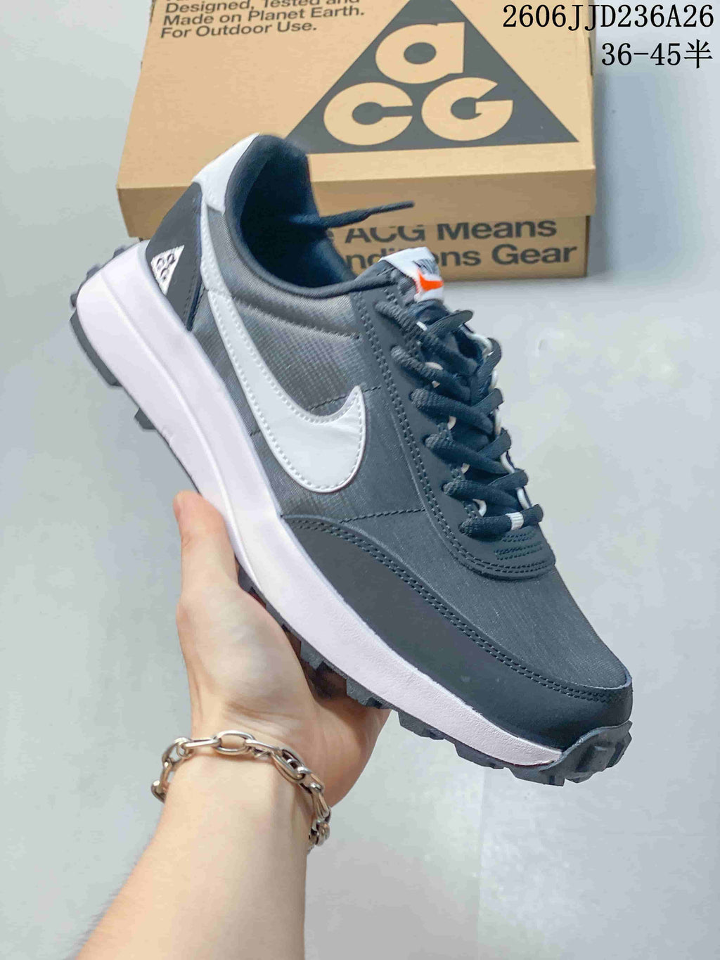 Angled side view showing the dark gray upper, white Swoosh, white midsole, and rugged outsole.