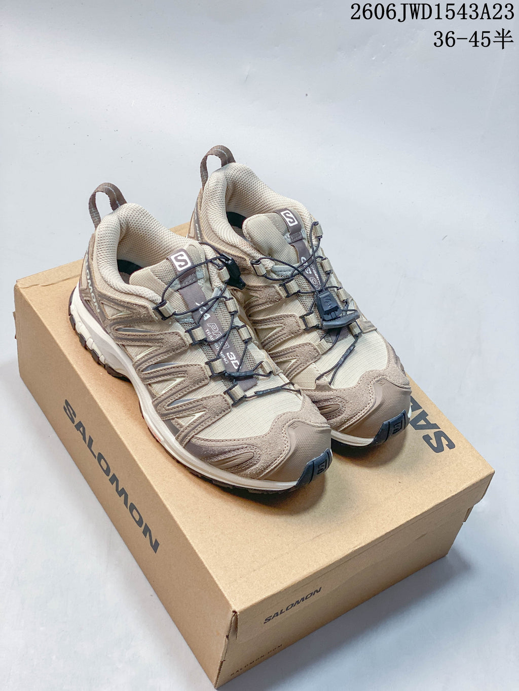 Pair of beige and taupe Salomon XA Pro 3D shoes on a branded box