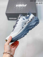Side profile showing the white and gray upper, navy midsole and rugged low-top hiking construction.